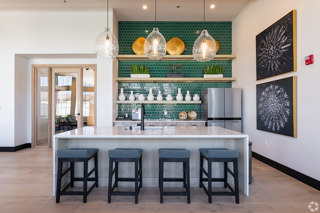 A bar area with a green tile backsplash and a white counter.