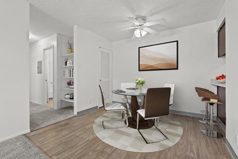 A dining room with a white table and chairs.