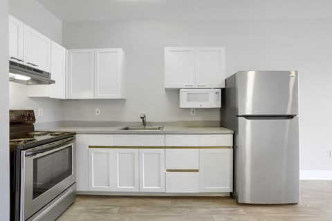 A modern kitchen with white cabinets and stainless steel appliances.