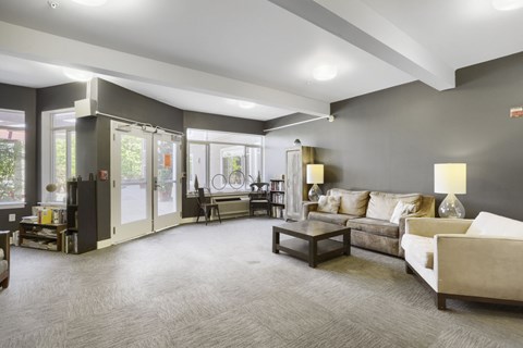 A living room with a grey carpet and furniture.