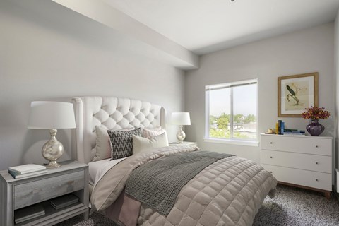 Bedroom with tufted headboard and white dresser at Stadium Station Apartments, Portland, OR