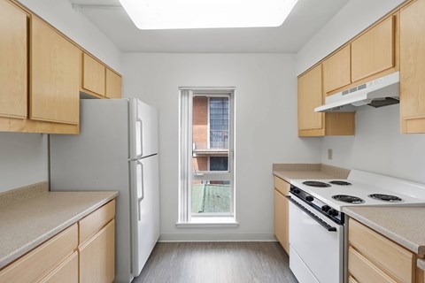 A kitchen with a window overlooking a balcony.