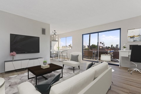 a living room with a couch and a tv and a balcony