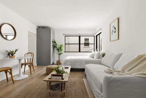 a living room with two couches and a table and a bed
