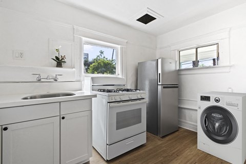 a kitchen with white cabinets and stainless steel appliances and a washing machine