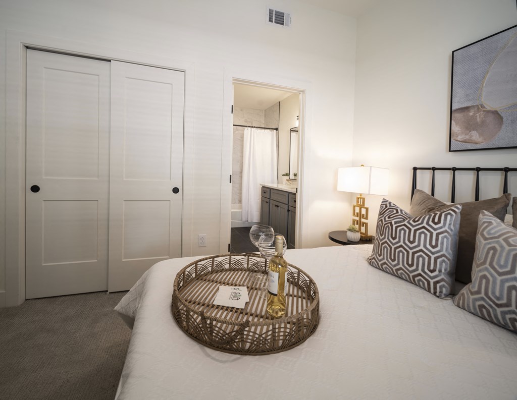 a bedroom with a white bed and a basket on top of it