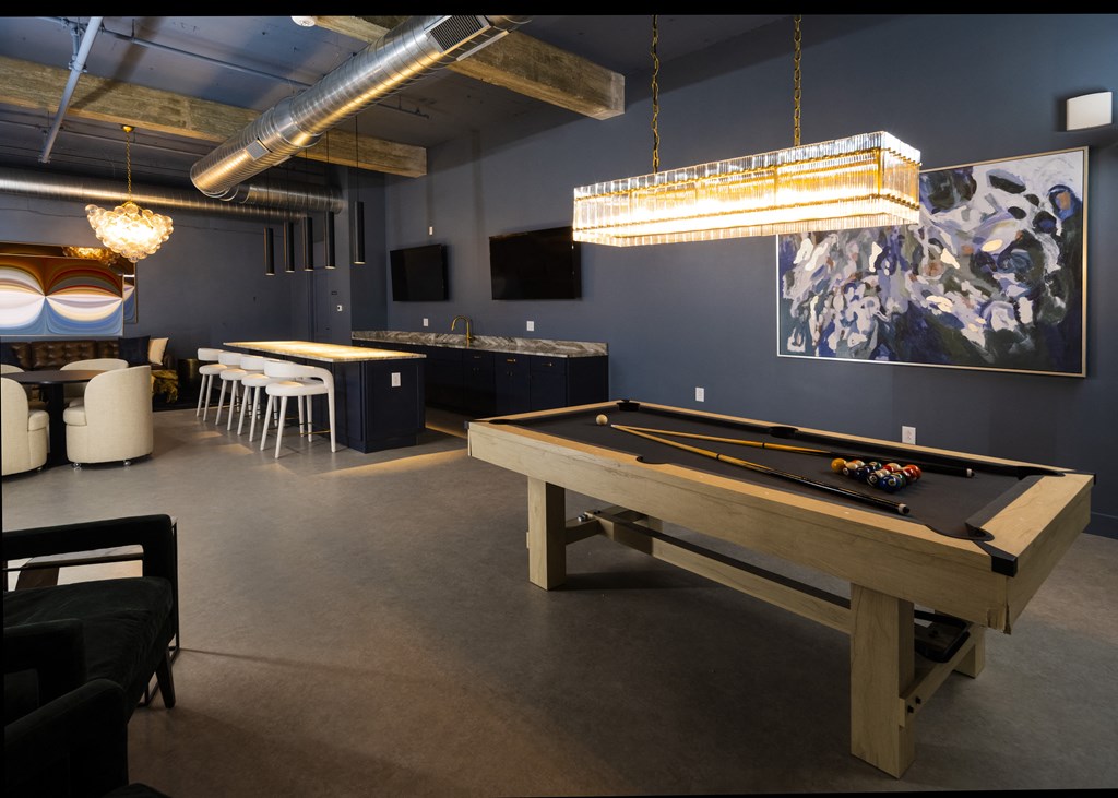 A game room with a pool table and a bar