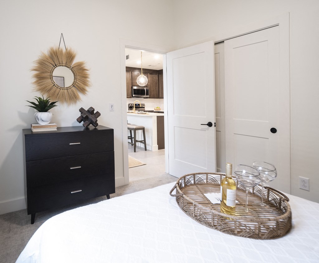 a bedroom with a bed and a dresser with a mirror on the wall