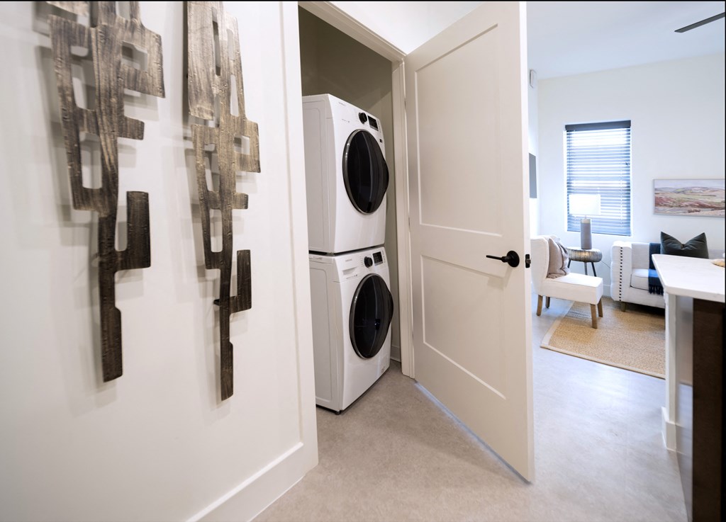 a laundry room with a washer and dryer and a door to a room