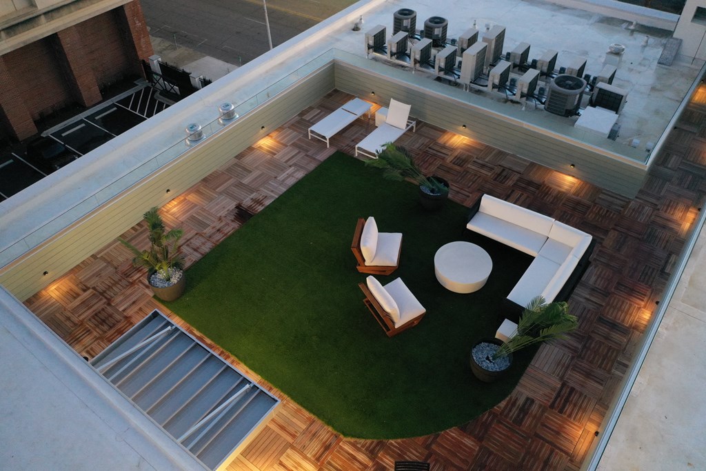 a roof top view of a living area with furniture and grass