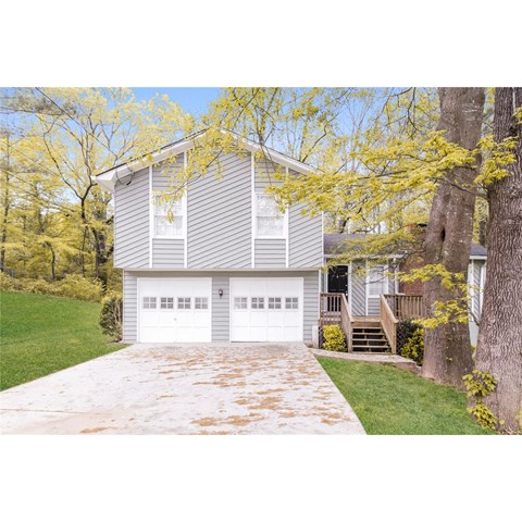 the front of the house with a driveway and a garage door
