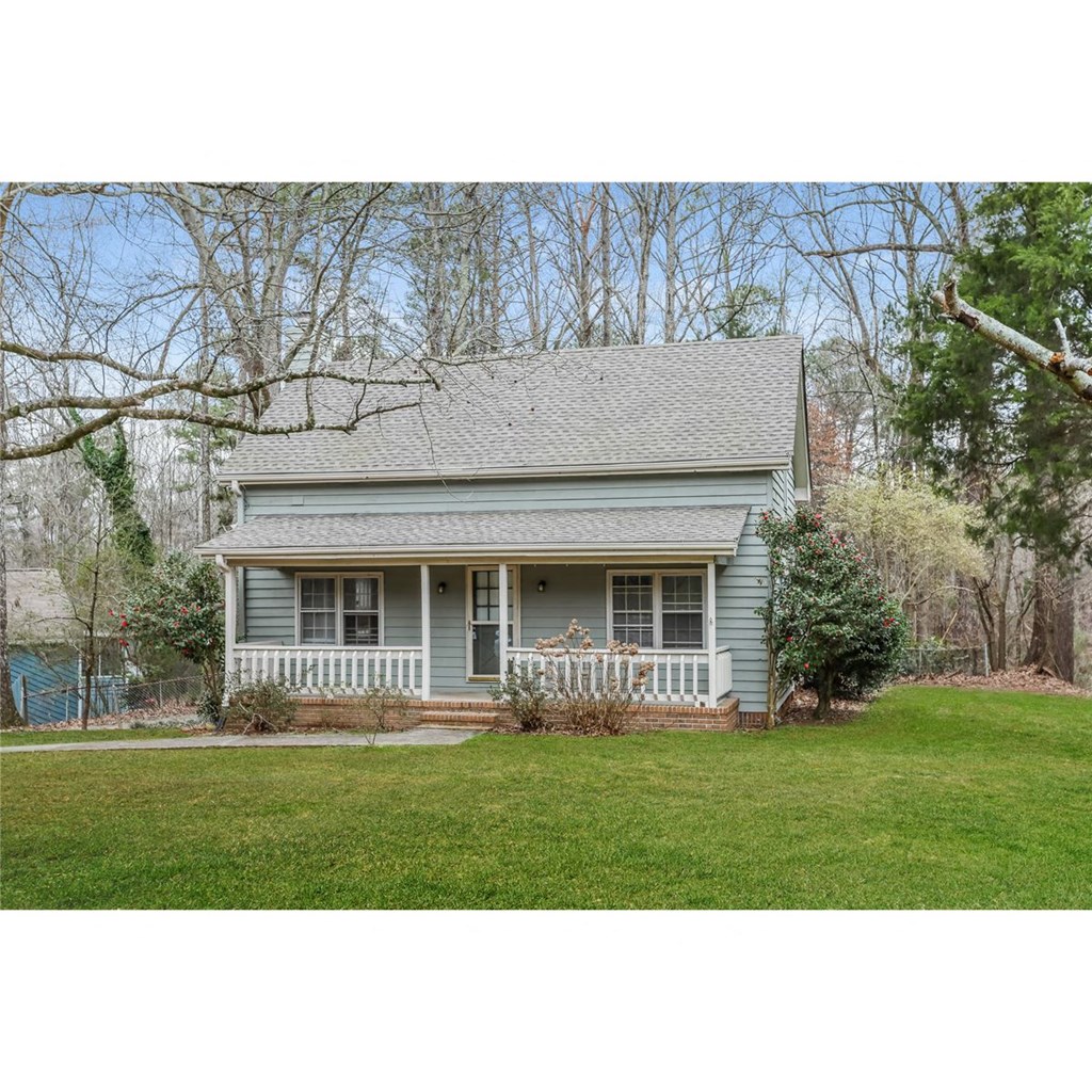this is a picture of a blue house with a lawn and trees