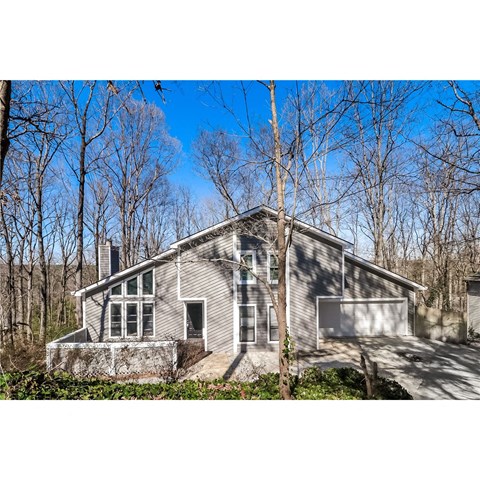 a small house in the woods with trees