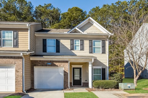 A two-story house with a garage and a driveway.