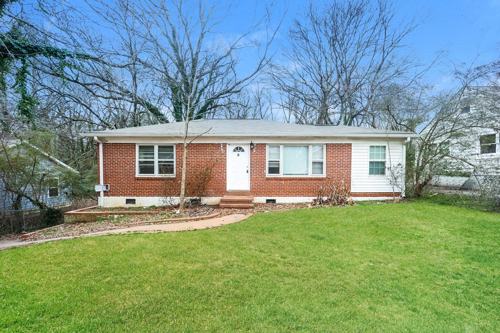 A red brick house with a white door and windows.