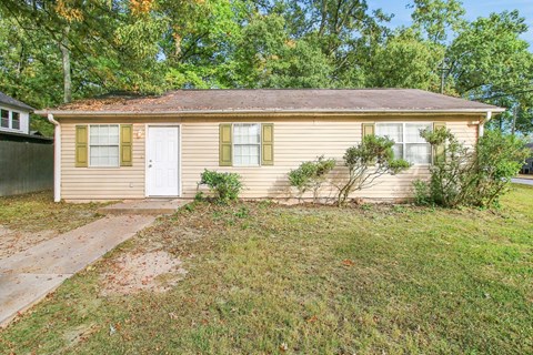 A small house with a white door and a small front yard.