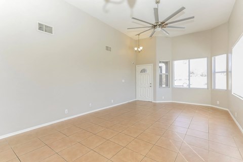 A spacious room with a ceiling fan and tile flooring.