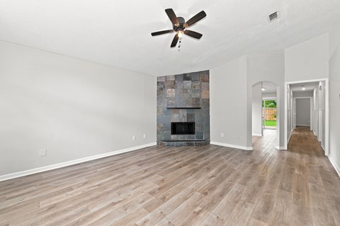 A room with a fireplace and a ceiling fan.