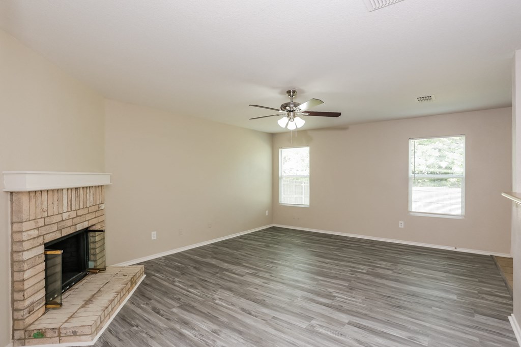 A room with a fireplace and a ceiling fan.
