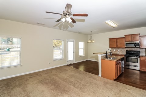 an empty kitchen and living room with a ceiling fan