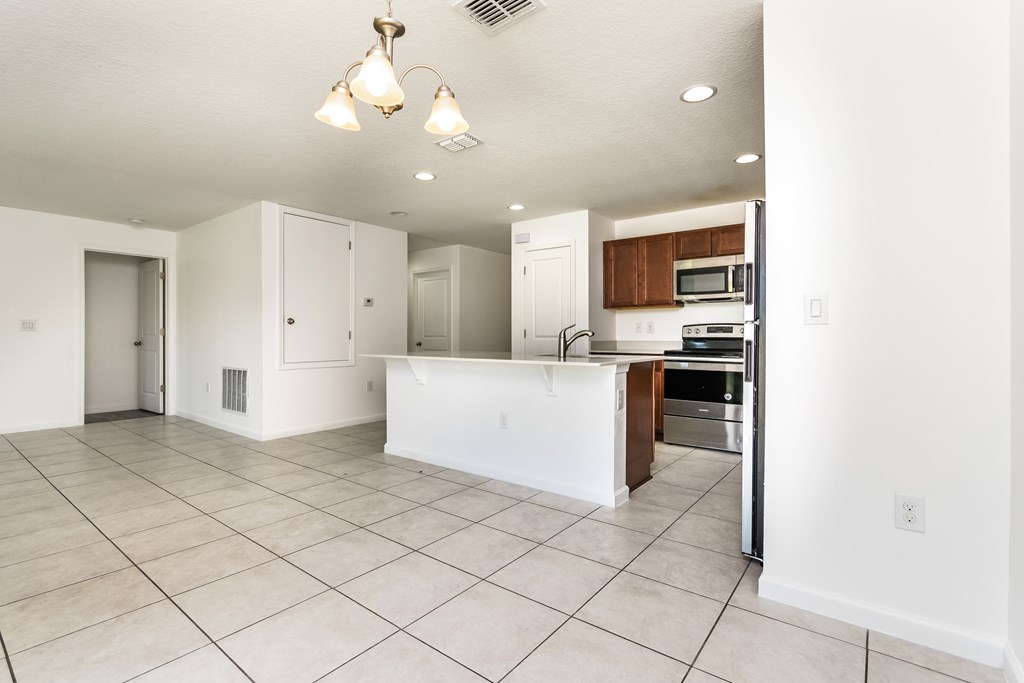 A kitchen area with a white counter and a refrigerator.