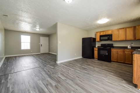 A kitchen with wooden cabinets and a black refrigerator.