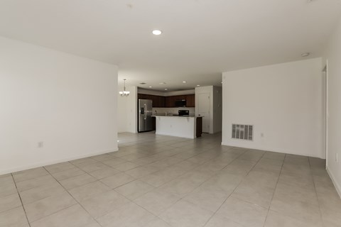 A spacious, empty room with white walls and a tiled floor.