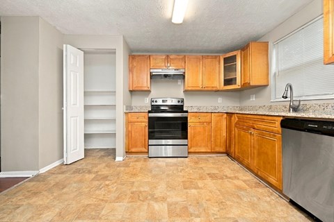 A kitchen with wooden cabinets and a black stove top oven.
