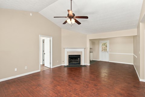 A living room with a fireplace and wood flooring.