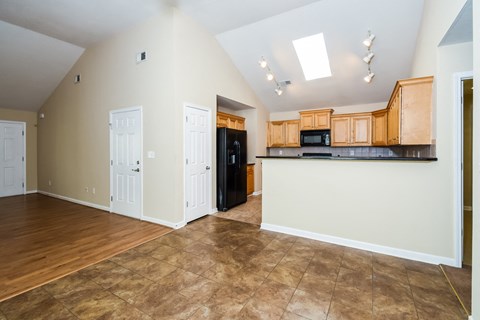 A kitchen area with wooden cabinets and a black refrigerator.