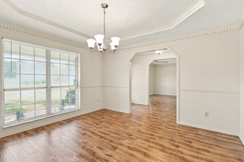 A room with wooden floors and a chandelier.