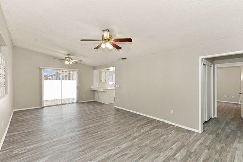 A spacious room with a ceiling fan and sliding glass doors.