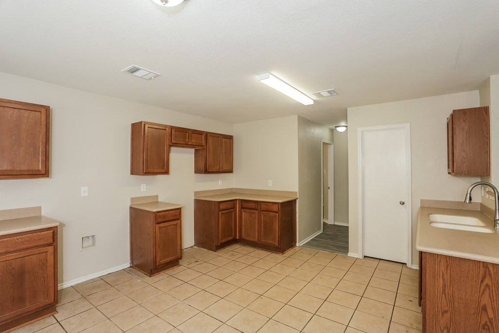 A kitchen with brown cabinets and a white door.