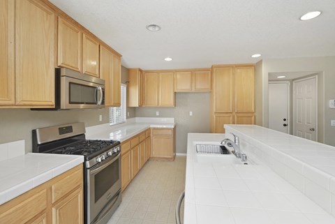 A kitchen with wooden cabinets and a white countertop.