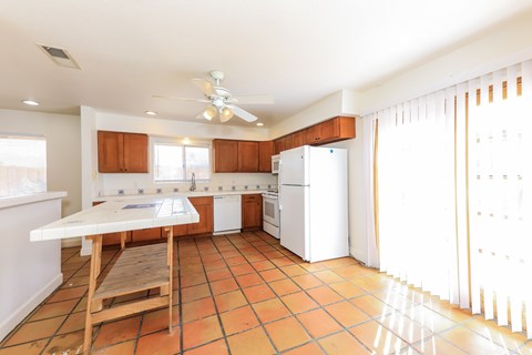 A kitchen with a table and chairs.