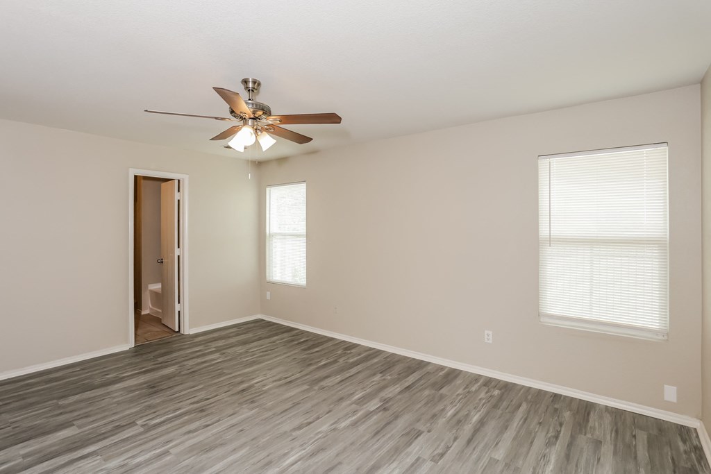 A room with a ceiling fan and a door.