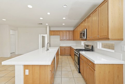 A kitchen with wooden cabinets and white countertops.