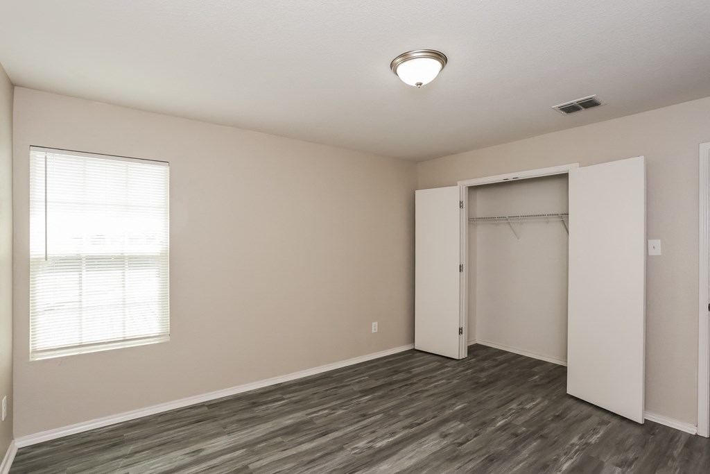 A room with a wooden floor and a large window.