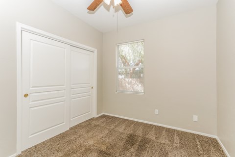 A room with a white door and a window with blinds.