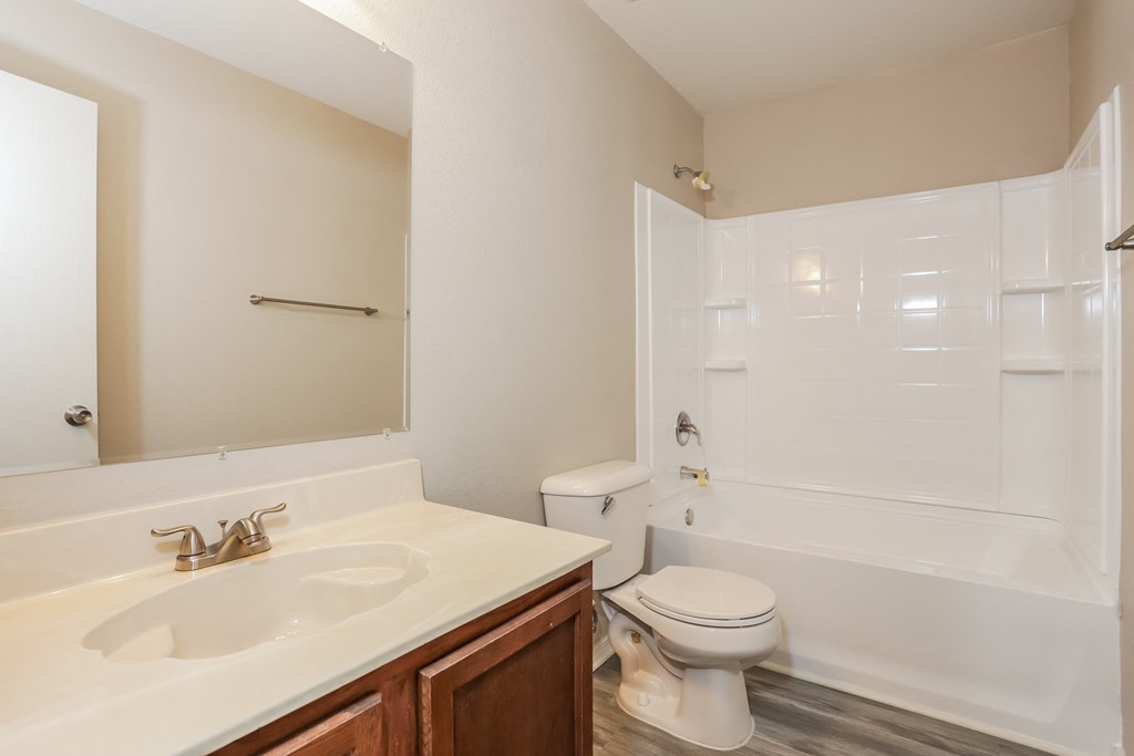 A white bathroom with a toilet, sink, and bathtub.