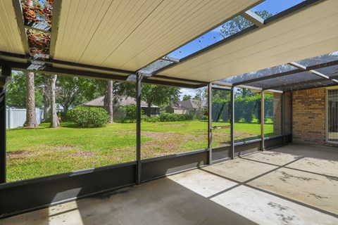 A patio with a white roof and a brick wall.