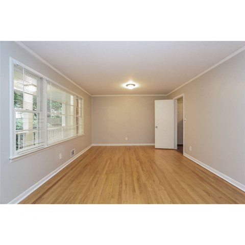 a spacious living room with wood floors and a large window