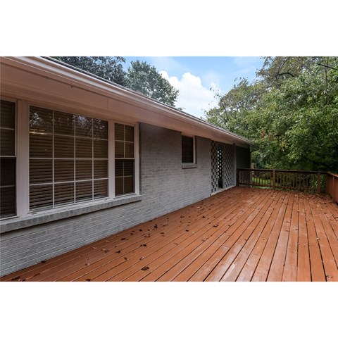A wooden deck is attached to a house.