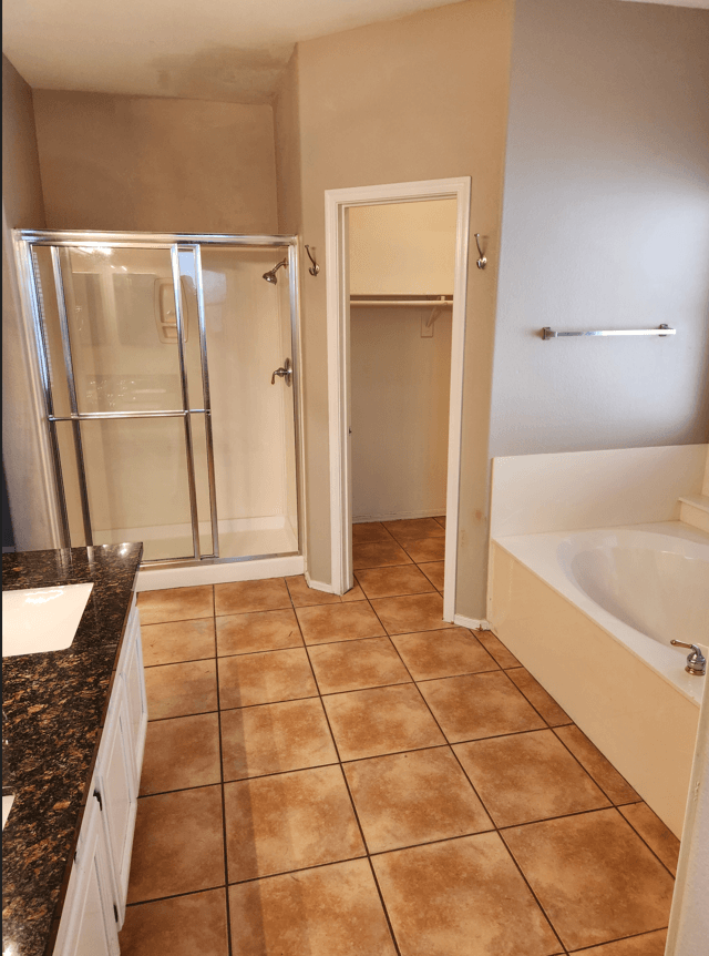 a bathroom with a tub and a shower and a sink