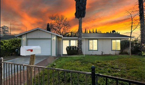 a house at sunset with the sky behind it