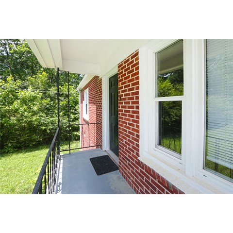 a view of the front porch of a brick house