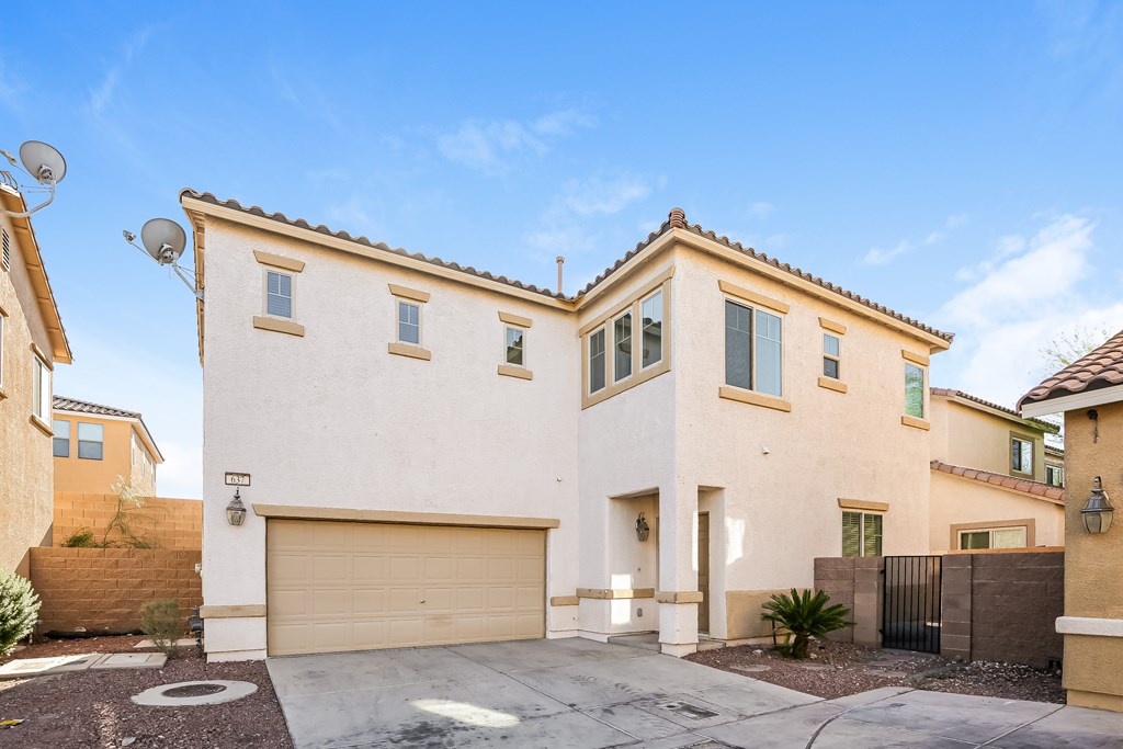 A modern house with a garage door and a driveway.