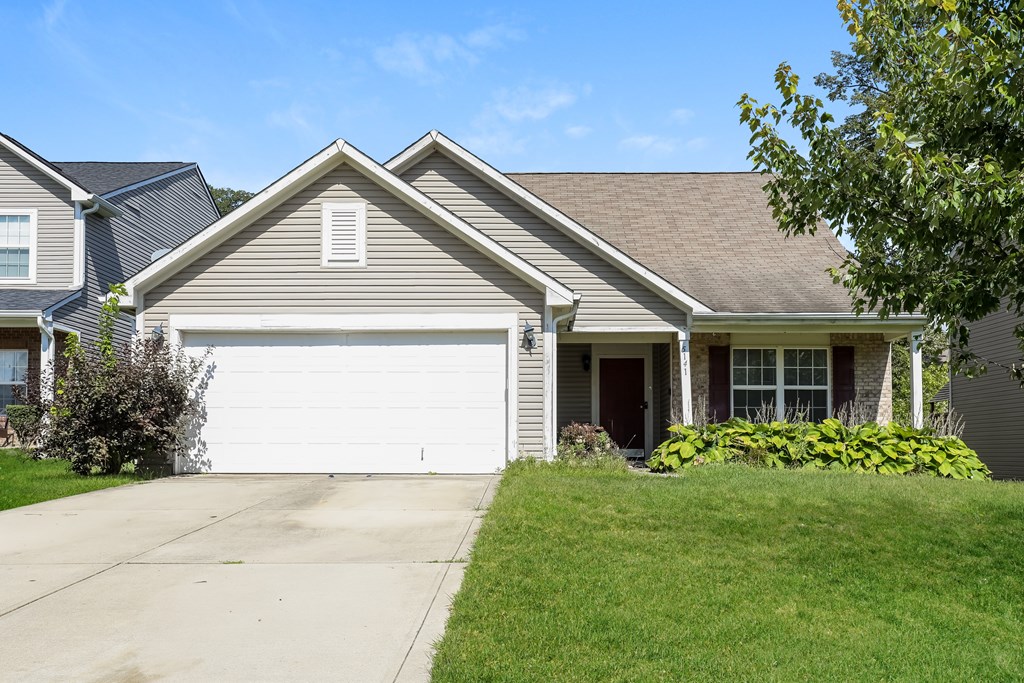 A house with a grey roof and a white garage door.