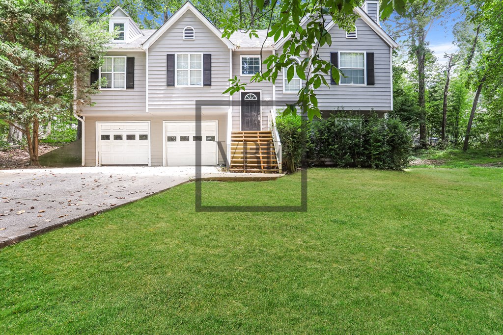 A house with a grey facade and a white garage door.