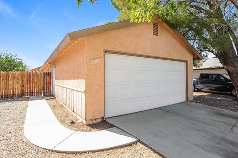 A tan house with a white garage door.